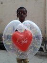 A happy cute little boy holding a heart shape balloon Royalty Free Stock Photo