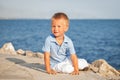 Happy cute little boy sitting on sand at beach Royalty Free Stock Photo