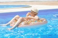 Happy cute little boy teenager lying on inflatable donut ring with orange in swimming pool. Active games on water, vacation Royalty Free Stock Photo