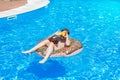 Happy cute little boy teenager lying on inflatable donut ring with orange in swimming pool. Active games on water, vacation Royalty Free Stock Photo