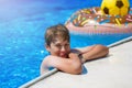 Happy cute little boy teenager in swimming pool. Active games on water, vacation, holidays concept. Chocolate donut. Royalty Free Stock Photo