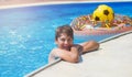 Happy cute little boy teenager in swimming pool. Active games on water, vacation, holidays concept. Chocolate donut. Royalty Free Stock Photo