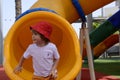 Happy cute little child boy having fun on a yellow tube slide Royalty Free Stock Photo