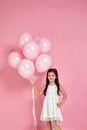 Happy cute little child girl posing with pastel pink air balloons Royalty Free Stock Photo