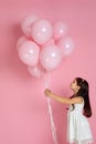Happy cute little child girl posing with pastel pink air balloons Royalty Free Stock Photo
