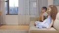 Happy cute little children watch the TV, kids relaxing at home using watch TV home, huggi,little girl and boy sitting on