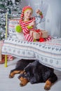 Happy cute little girl dressed in striped pajamas sitting in decorated New Year room at home. Royalty Free Stock Photo