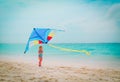 Happy cute little girl flying a kite on beach Royalty Free Stock Photo