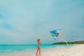 Happy cute little girl flying a kite on beach Royalty Free Stock Photo