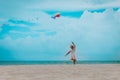 Happy cute little girl flying a kite on beach vacation Royalty Free Stock Photo