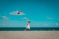 Happy cute little girl flying a kite at sky on beach Royalty Free Stock Photo