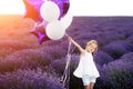 Happy cute little girl in lavender field with purple balloons. Freedom concept. Royalty Free Stock Photo
