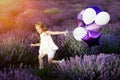 Happy cute little girl in lavender field with purple balloons. Freedom concept. Royalty Free Stock Photo