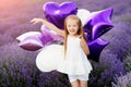 Happy cute little girl in lavender field with purple balloons. Freedom concept.