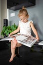 Happy cute little girl looking at photos in album. Happy smiling daughter browsing through printed family album, looking Royalty Free Stock Photo