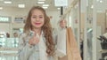 Happy cute little girl showing thumbs up at the shopping mall Royalty Free Stock Photo