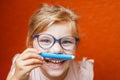 Happy cute little preschooler girl with glasses holding colorful pencils and making gesture while looking at camera Royalty Free Stock Photo