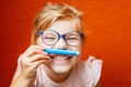 Happy cute little preschooler girl with glasses holding colorful pencils and making gesture while looking at camera Royalty Free Stock Photo