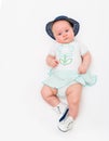 Happy cute 4 months old smiling baby in jeans hat on a white background.