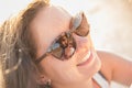 Happy cute mother helps smiling child to wear helmet in sunglasses reflection