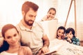 Happy Cute Parents Reading Book while Kids Playing Royalty Free Stock Photo