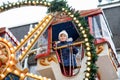 Happy cute preschool girl riding on ferris wheel carousel horse at Christmas funfair or market, outdoors. Little toddler Royalty Free Stock Photo