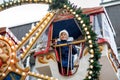 Happy cute preschool girl riding on ferris wheel carousel horse at Christmas funfair or market, outdoors. Little toddler Royalty Free Stock Photo