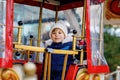 Happy cute preschool girl riding on ferris wheel carousel horse at Christmas funfair or market, outdoors. Little toddler Royalty Free Stock Photo