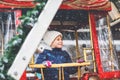 Happy cute preschool girl riding on ferris wheel carousel horse at Christmas funfair or market, outdoors. Little toddler