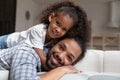 Happy African child cuddling smiling father at home. Royalty Free Stock Photo