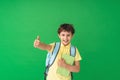 Happy cute smart boy with a school bag and a book in his hand Royalty Free Stock Photo