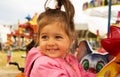 Happy cute smiling little girl riding on carousel in summer day Royalty Free Stock Photo