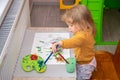 Happy cute toddler painting her face with gouache paints. Children development concept