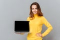 Happy cute woman showing blank laptop computer screen Royalty Free Stock Photo