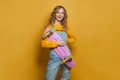 Happy cute woman with skateboard on bright yellow background. Positive emotion Royalty Free Stock Photo