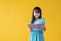 A happy and cute young Asian girl is reading a book or her favourite fairy tale Royalty Free Stock Photo
