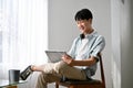 Happy cute young Asian man in casual clothes using a digital tablet. lifestyle concept Royalty Free Stock Photo