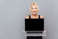 Happy cute young woman holding blank screen laptop Royalty Free Stock Photo