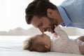 Happy dad calming, comforting baby resting on back in bed Royalty Free Stock Photo