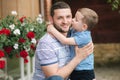 Happy dad with his little sun outdoors. Sun kiss his father cheek Royalty Free Stock Photo