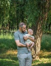 Happy dad holding his baby son on hands on the background of a summer landscape Royalty Free Stock Photo