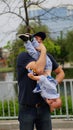 Happy dad holding his son on arm upside down, walking together in a park Royalty Free Stock Photo