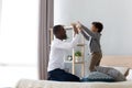 Happy dad playing with little biracial son in bedroom Royalty Free Stock Photo