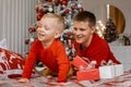 Happy dad tickle and have fun with excited small son near Christmas tree. Relax together, loving father playing with smiling Royalty Free Stock Photo