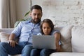 Happy dad watching focused schoolkid son using learning online app Royalty Free Stock Photo