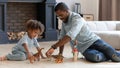 Happy daddy and toddler son playing games with small dinosaurs