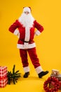 Happy dancing Santa Claus with hands on his waist, leg on heel