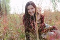 Happy dark-haired lady smiling in bitween red autumnal grass Royalty Free Stock Photo
