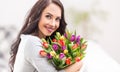 Happy dark haired woman holding a lovely bouquet full of tulips during national womens day