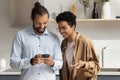 Happy dating young Black couple using online app on cellphones